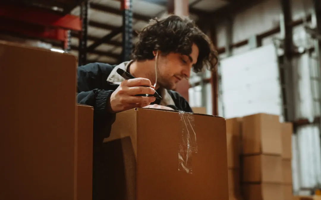 gentleman writing on box with marker