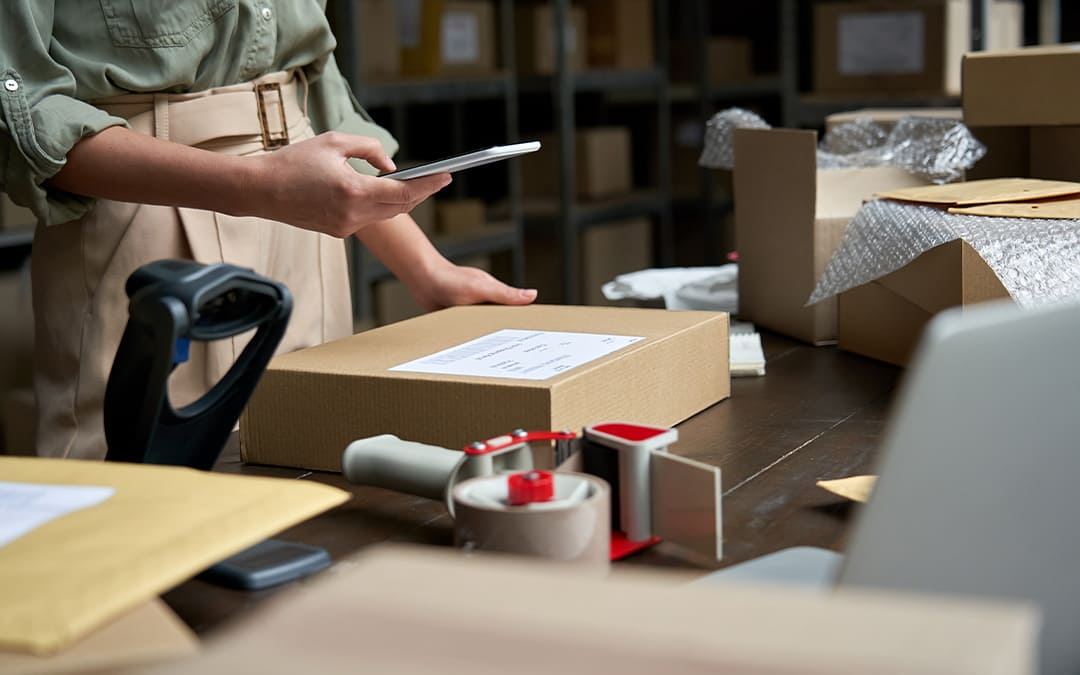 Female small business owner using mobile app on smartphone checking parcel box